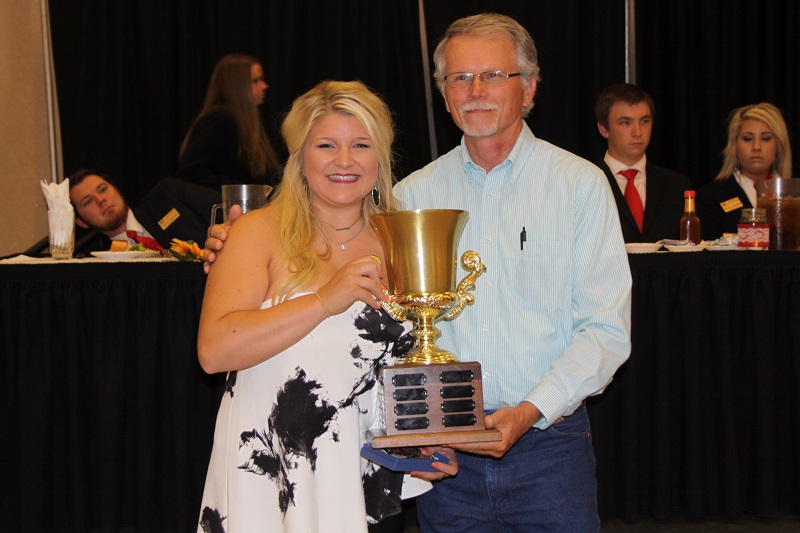 2016<br><br>Kalli Ellis<br><br>Mike Griffith, BPG Director, is making the presentation.<br><br>Kalli receives a beautiful belt buckle, donated by C & A Beefmasters - Craig and Andrea Reed, and her name is added to the awesome cup that is passed down to the 2017 winner.<br><br><a href='page.php?id=107'>Memorial to Pevine Hicks</a>